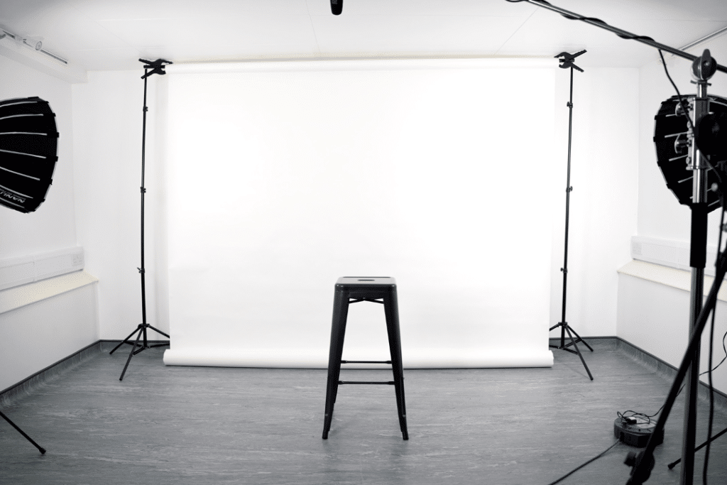 A chair on a white back drop with two cameras either side - filming for christmas ai