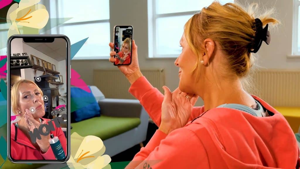 Showing a blonde haired woman scanning an interactive, AR filter wine packaging to reveal an interactive experience